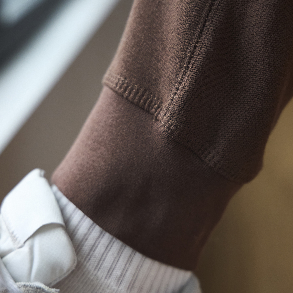 A close up image of the ankle of brown sweatpants