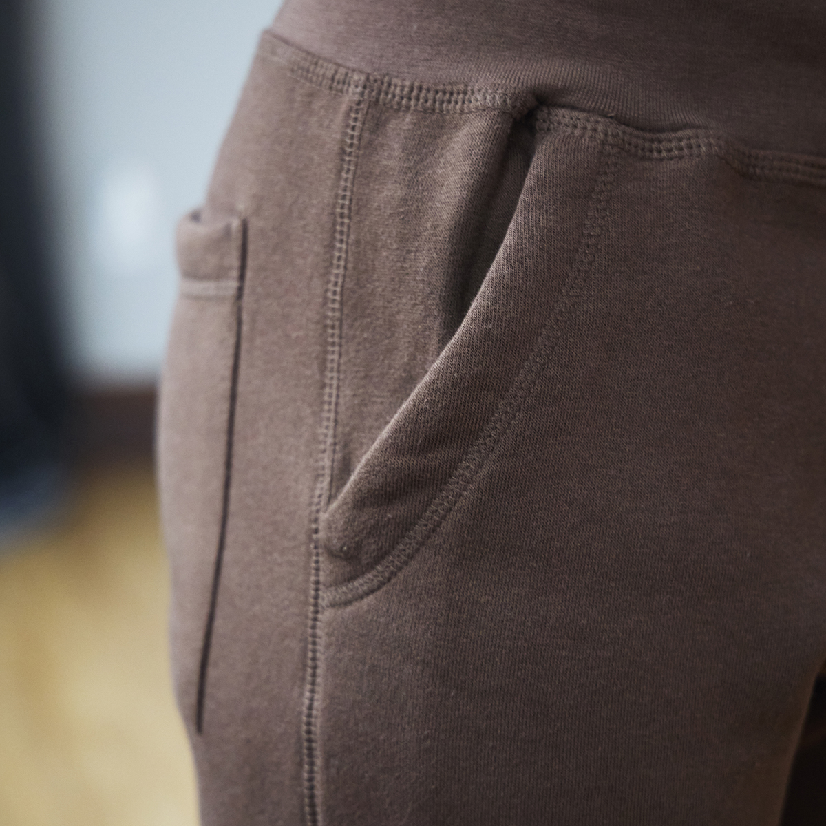 The side pocket of brown sweatpants