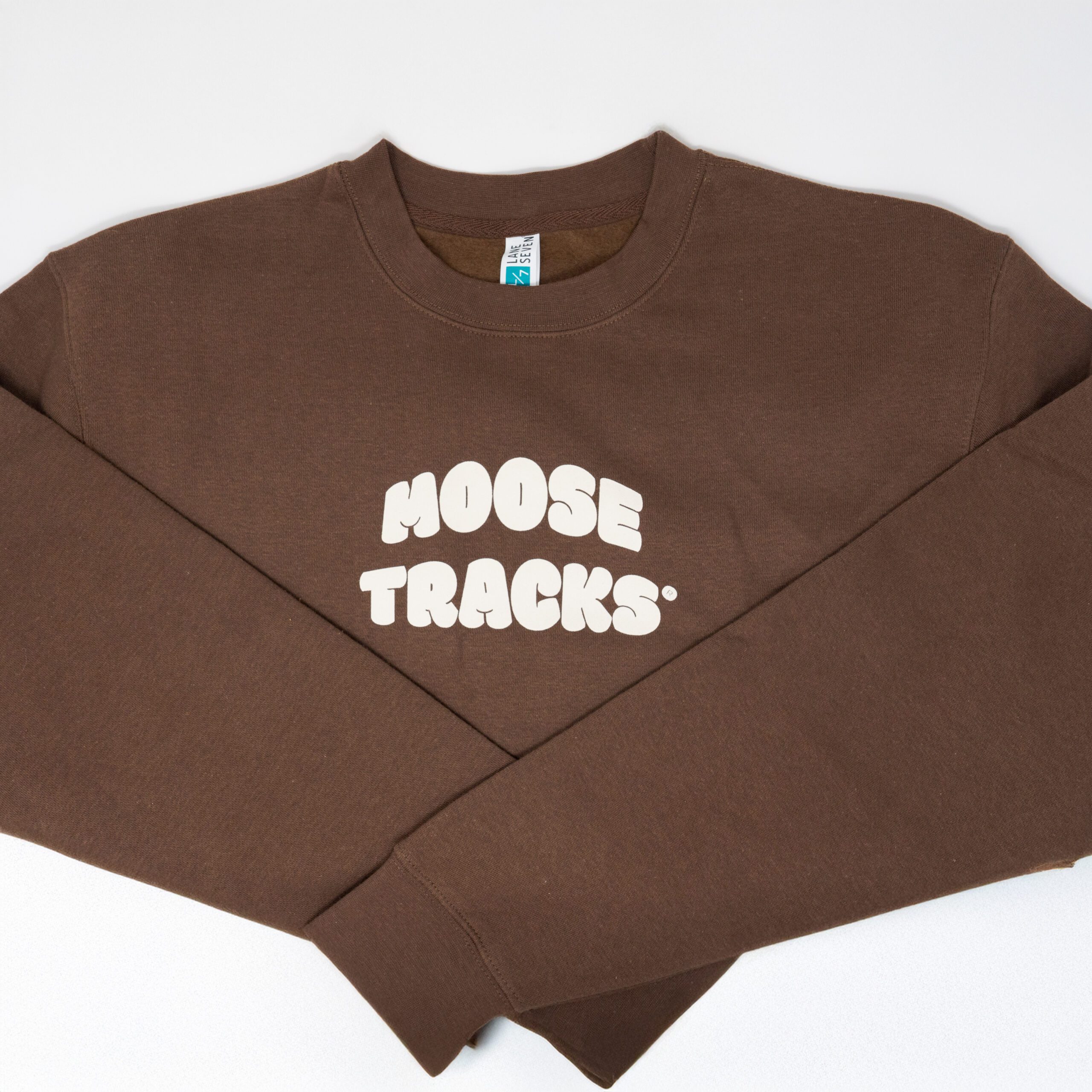 A brown crewneck sweatshirt with "Moose Tracks" in vanilla-colored screen printing
