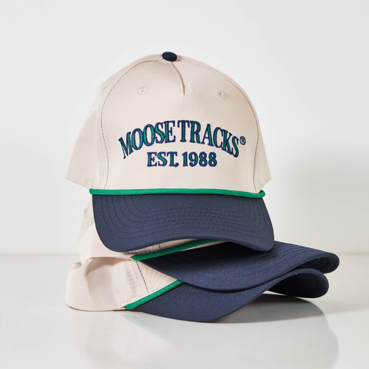 Three white and blue Moose Tracks Two-Two Rope Hats stacked on top of each other. The top hat has "Moose Tracks EST. 1988" printed on the front.